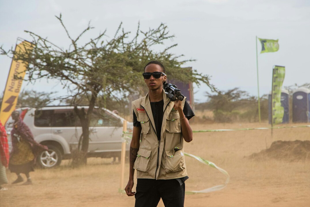 Field reporter speaking into a microphone outdoors